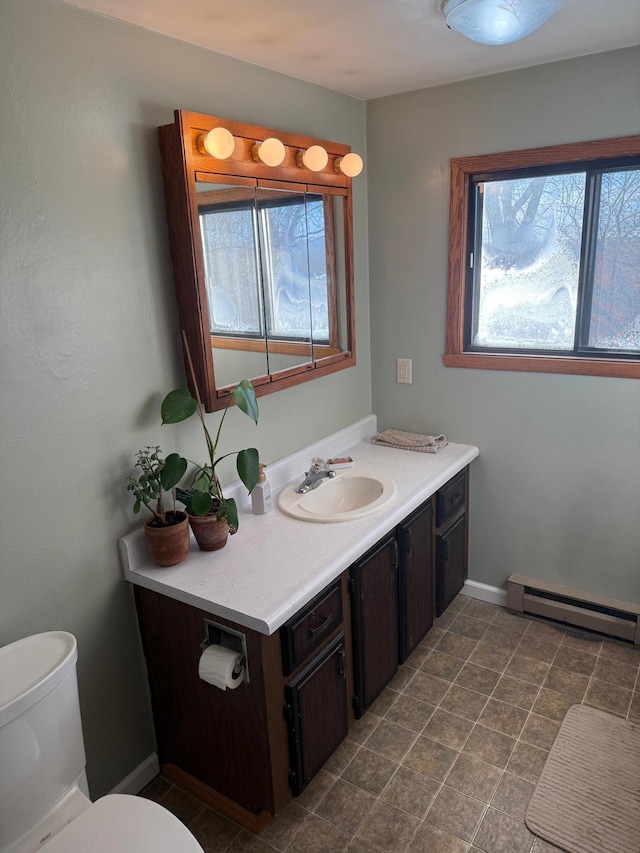 bathroom featuring vanity, toilet, and baseboard heating