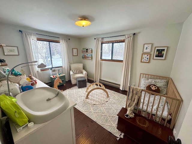 playroom with dark hardwood / wood-style flooring and a baseboard heating unit