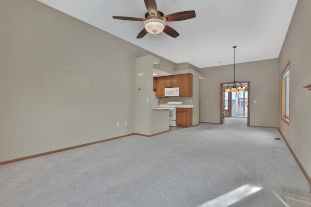 unfurnished living room featuring ceiling fan with notable chandelier and light colored carpet