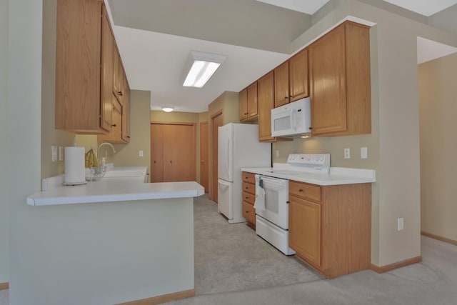 kitchen with kitchen peninsula, light carpet, sink, and white appliances