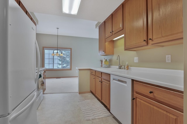 kitchen with white appliances, decorative light fixtures, and sink