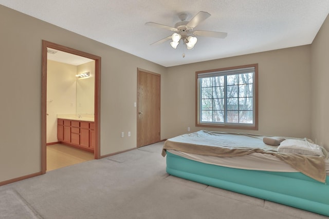 bedroom featuring connected bathroom, ceiling fan, light carpet, and a textured ceiling