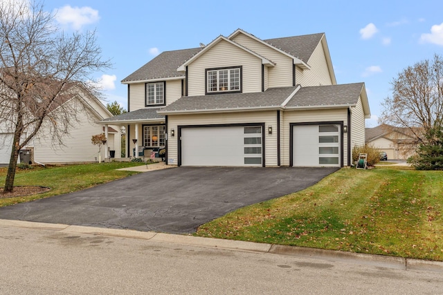 view of front of home with a front yard and a garage