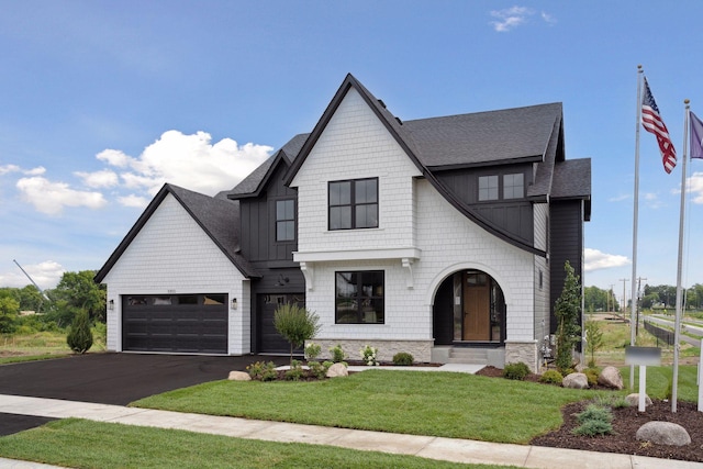 modern farmhouse featuring a garage and a front lawn