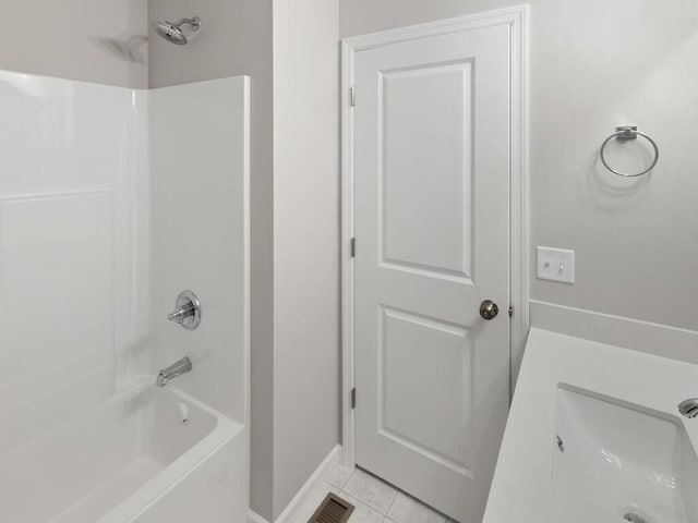 bathroom with tile patterned flooring, bathing tub / shower combination, and sink