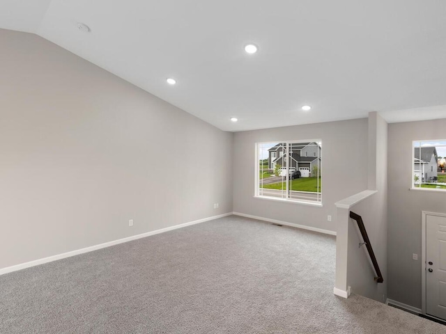 unfurnished living room featuring vaulted ceiling and carpet