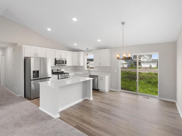 kitchen with sink, decorative light fixtures, white cabinetry, a center island, and appliances with stainless steel finishes