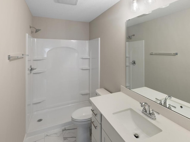 bathroom with walk in shower, vanity, and toilet