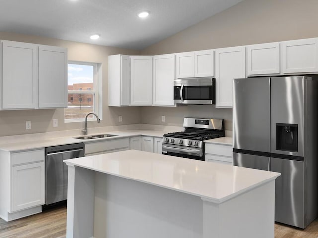 kitchen featuring white cabinetry, sink, stainless steel appliances, and a kitchen island