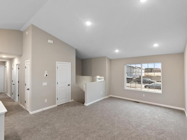 empty room with lofted ceiling and carpet floors