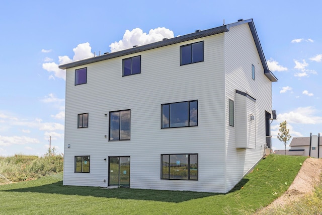 rear view of house featuring a lawn