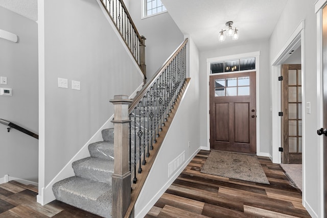 foyer featuring a textured ceiling and dark hardwood / wood-style floors