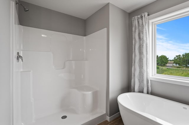 bathroom featuring hardwood / wood-style floors and independent shower and bath