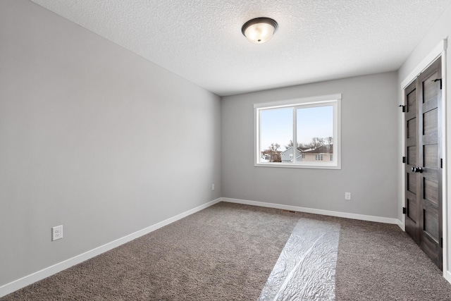 unfurnished room featuring carpet floors and a textured ceiling