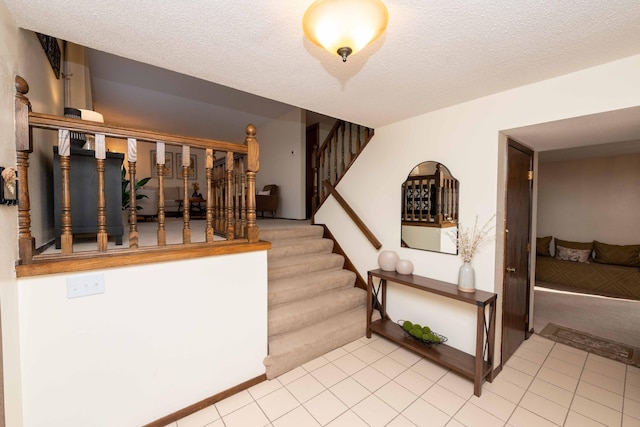 staircase featuring tile patterned floors and a textured ceiling