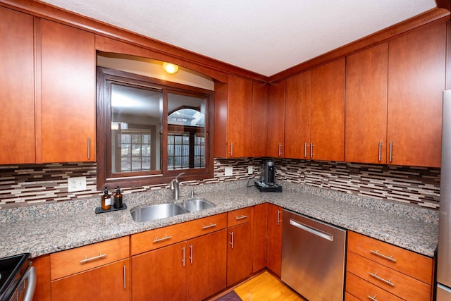 kitchen with appliances with stainless steel finishes, sink, decorative backsplash, and stone counters