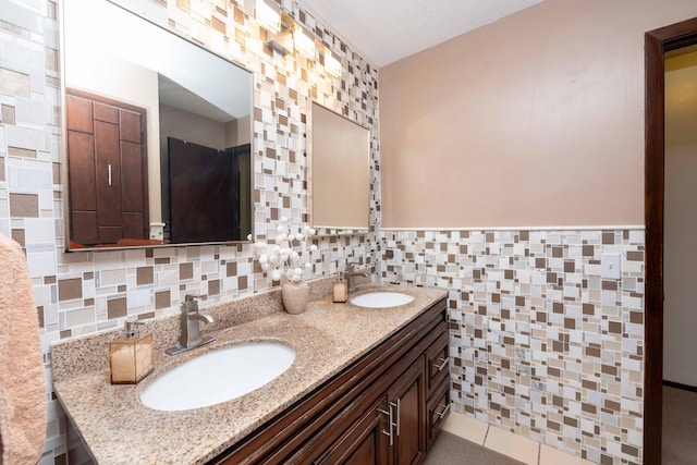 bathroom with tile walls, vanity, tile patterned floors, and a textured ceiling