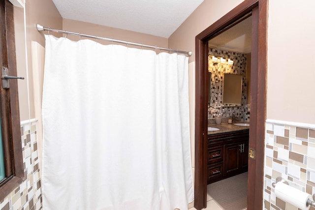 bathroom featuring vanity, decorative backsplash, and a textured ceiling