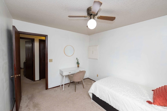 bedroom featuring ceiling fan, light colored carpet, and a textured ceiling