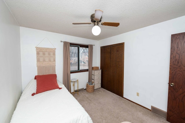 bedroom with ceiling fan, carpet floors, and a textured ceiling