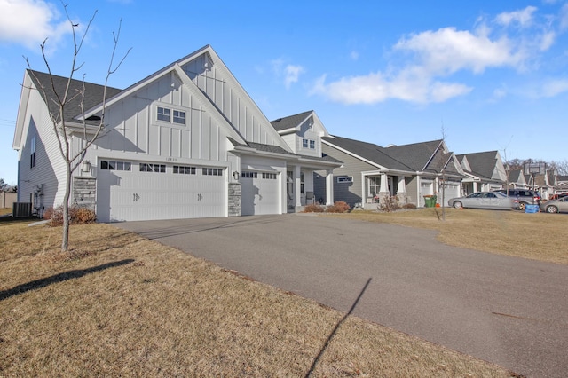 view of front of house with central AC, a front lawn, and a garage