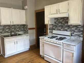 kitchen featuring sink, white cabinets, decorative backsplash, light hardwood / wood-style floors, and white gas range oven