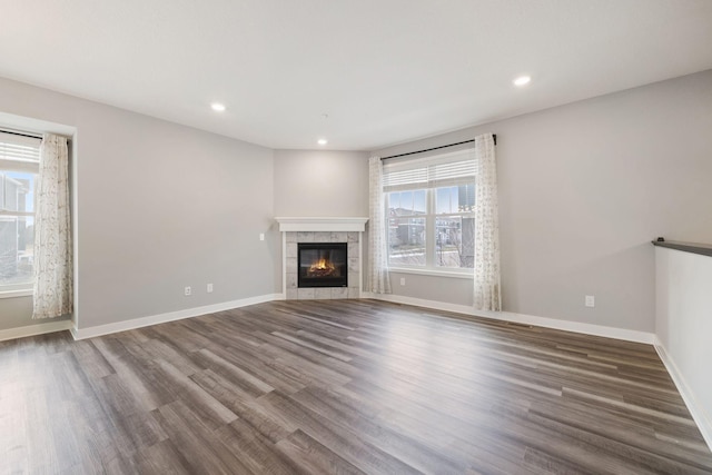 unfurnished living room with a tile fireplace and dark hardwood / wood-style floors