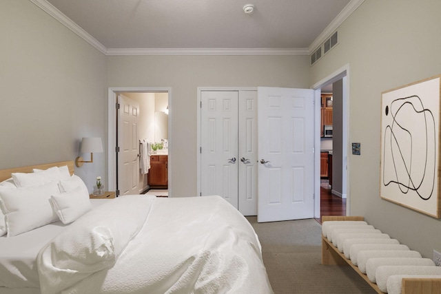 bedroom featuring carpet flooring, ensuite bath, crown molding, and a closet