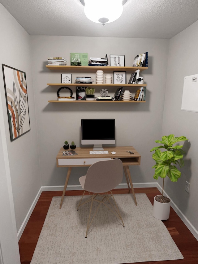 office with a textured ceiling and dark wood-type flooring