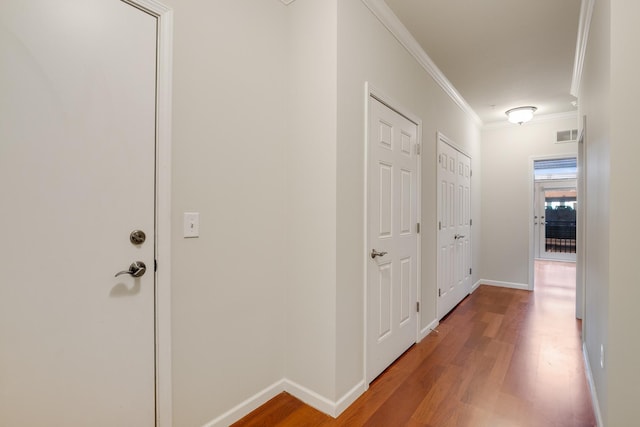 corridor featuring wood-type flooring and ornamental molding