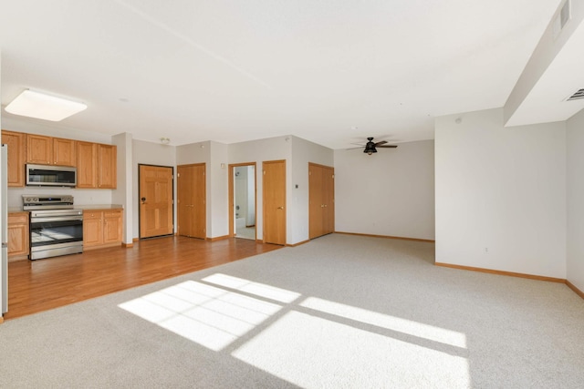 unfurnished living room with ceiling fan and light colored carpet