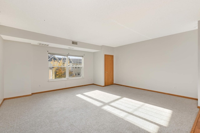 spare room featuring light colored carpet