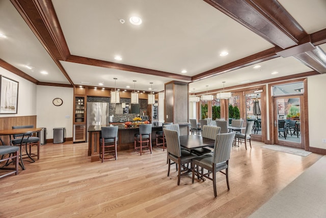 dining room with light hardwood / wood-style flooring and ornamental molding