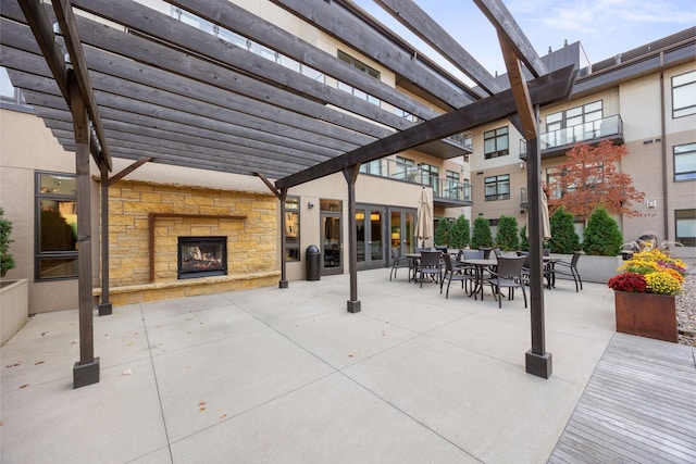 view of patio featuring an outdoor stone fireplace and a pergola