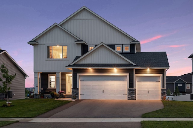 craftsman-style home with a garage, a yard, and central AC