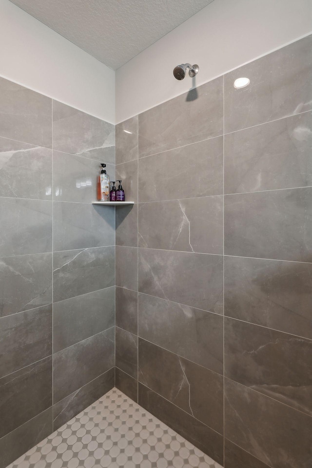 bathroom featuring tiled shower and a textured ceiling