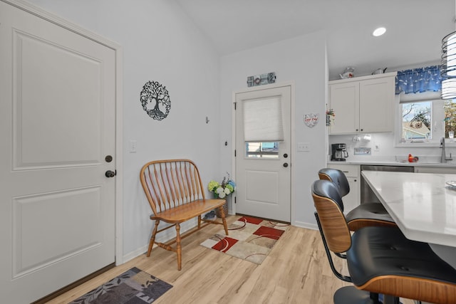 office area with light wood finished floors, baseboards, a sink, and recessed lighting