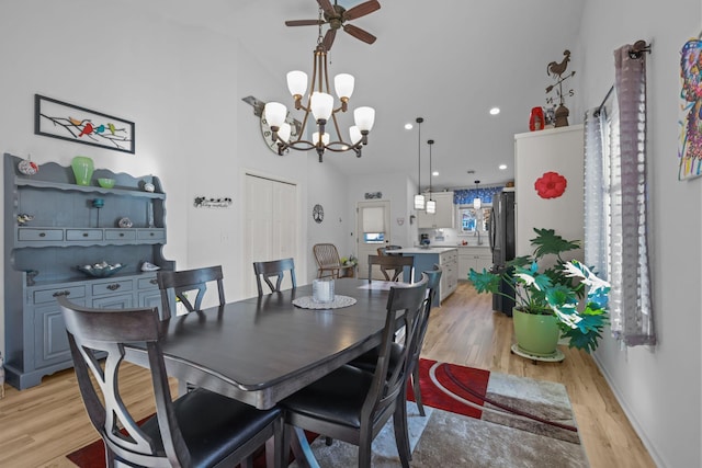 dining area with ceiling fan with notable chandelier, light wood finished floors, and recessed lighting