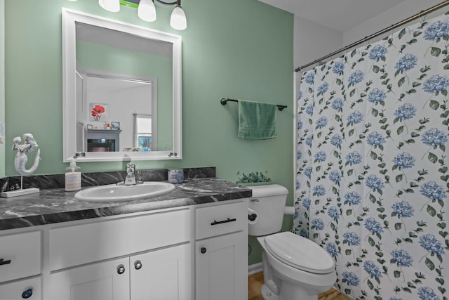 full bathroom with a shower with shower curtain, toilet, and vanity
