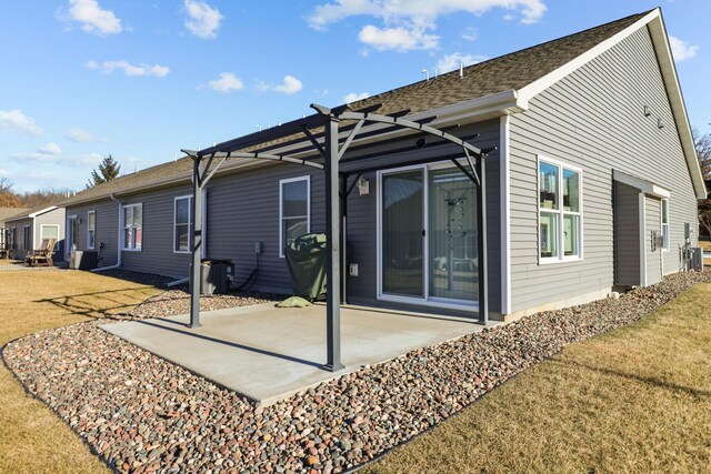 rear view of house featuring a patio area, roof with shingles, a yard, and a pergola