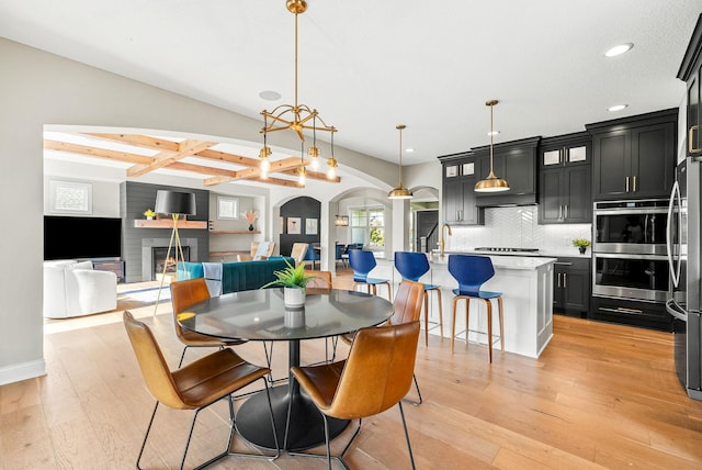 dining space featuring beam ceiling and light hardwood / wood-style floors