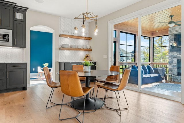 dining area featuring wood ceiling, a fireplace, and light hardwood / wood-style flooring