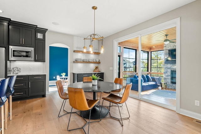 dining room with a fireplace and light hardwood / wood-style flooring