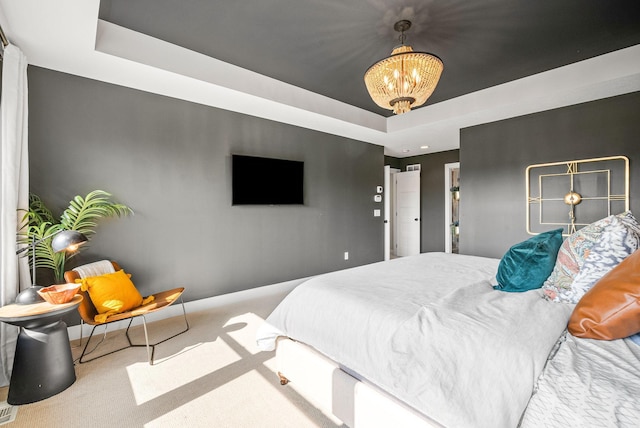 carpeted bedroom with a notable chandelier and a raised ceiling