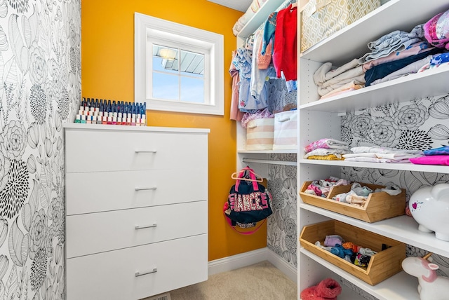 walk in closet featuring light carpet