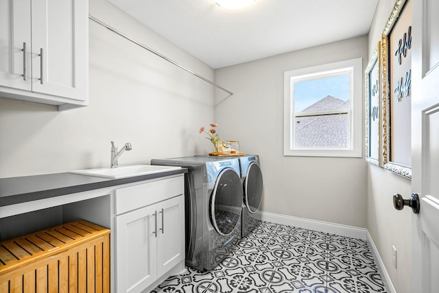 laundry area with cabinets, independent washer and dryer, sink, and light tile patterned floors