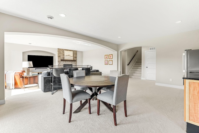 carpeted dining room featuring a fireplace