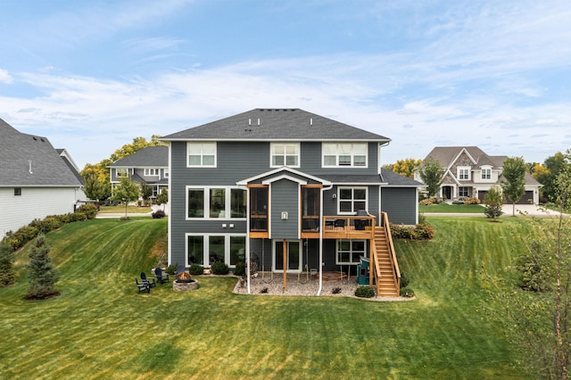 rear view of house featuring a wooden deck and a lawn