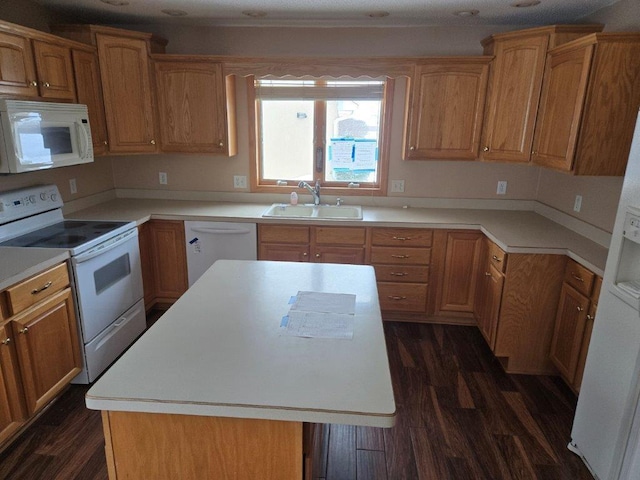 kitchen with sink, a kitchen island, dark hardwood / wood-style floors, and white appliances