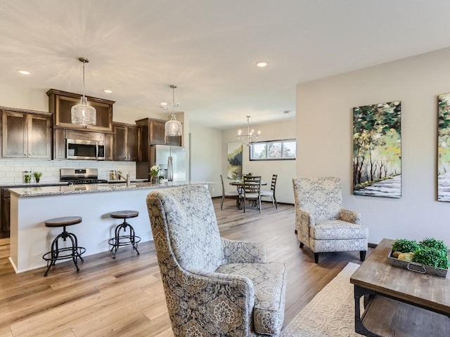 living room with light hardwood / wood-style flooring and a notable chandelier